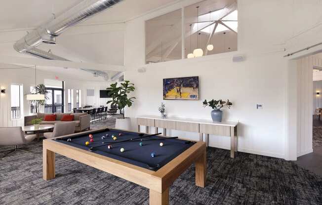 a games room with a pool table in the middle