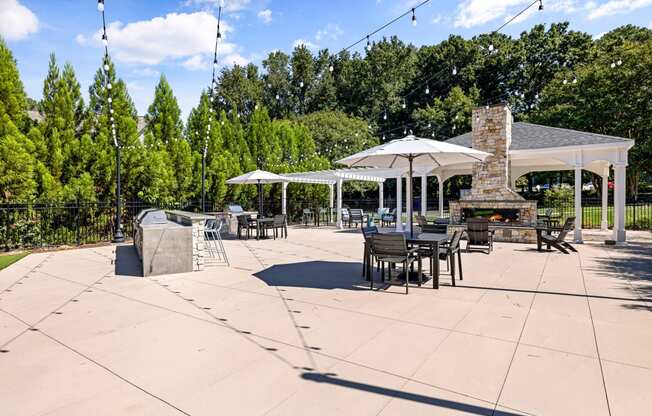 a patio with tables and umbrellas and a fire pit at View at Lake Lynn, Raleigh North Carolina