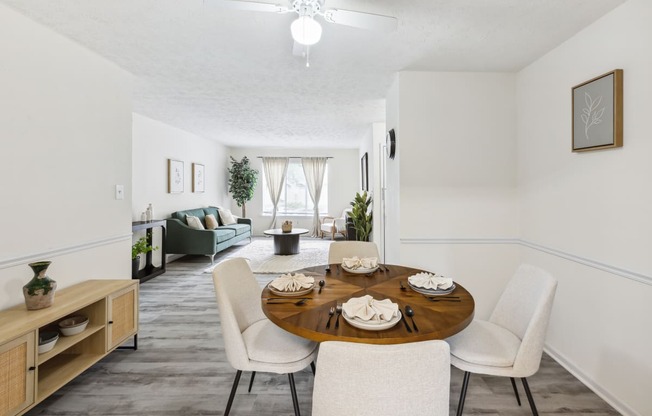 a living room and dining room with a table and chairs