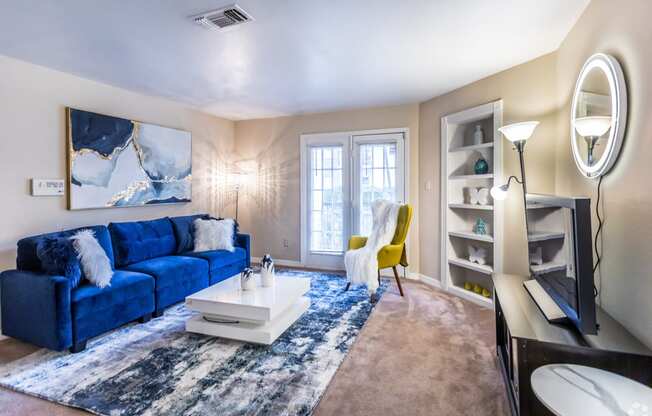 a living room with a blue couch and a white coffee table