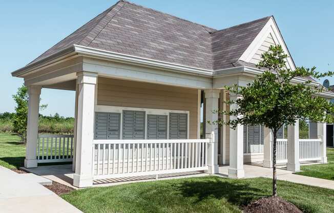 a house with a porch and a tree in front of it