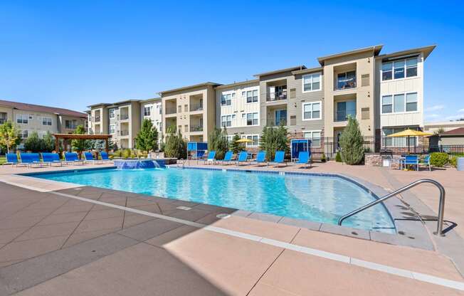 a swimming pool with an apartment building in the background