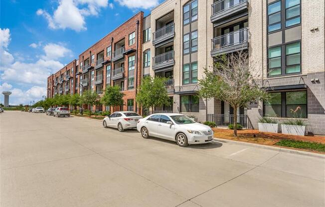 A white car is parked on the street in front of a building.