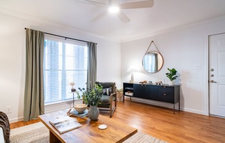 a living room with a ceiling fan and a large window