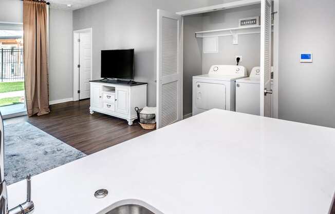 A modern kitchen with a white countertop and a stainless steel sink.