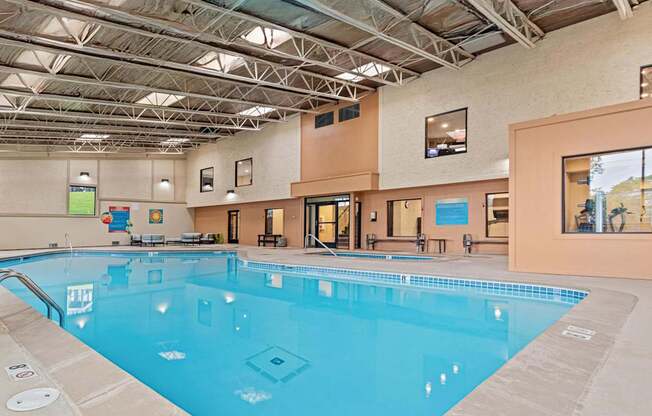 A large indoor swimming pool with a blue tiled bottom.