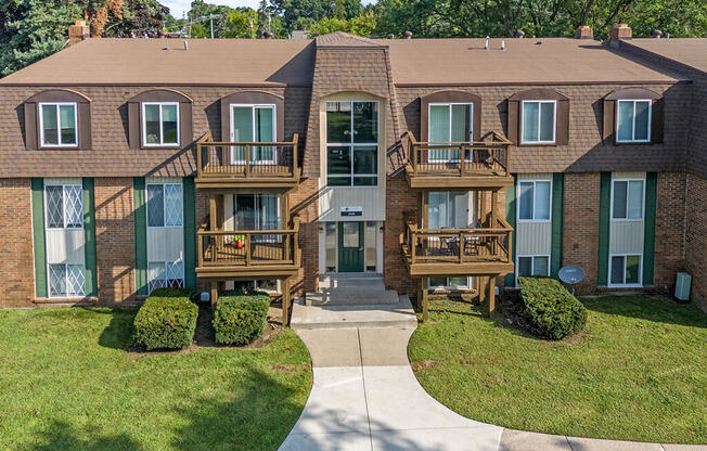 an apartment building with two balconies and a sidewalk