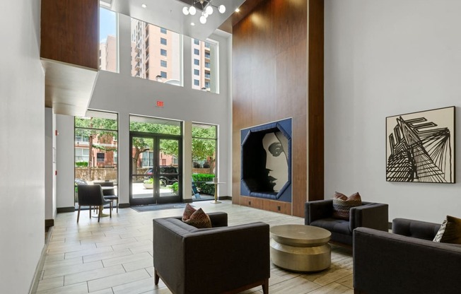 a lobby with couches and chairs and a painting on the wall