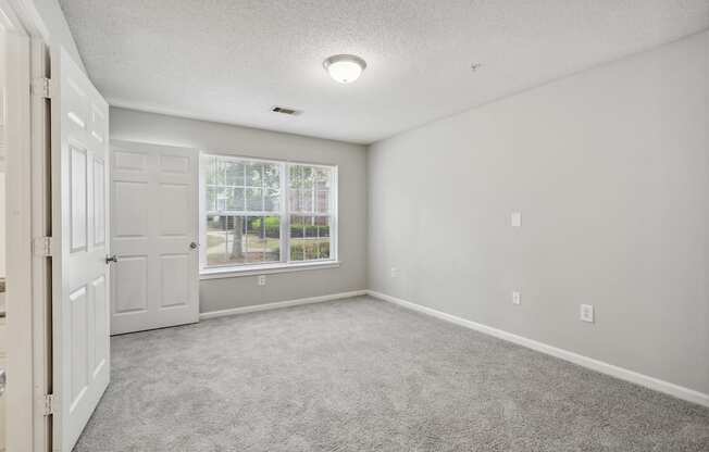 an empty room with a door and a window