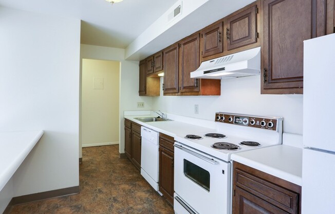 a kitchen with white appliances and wooden cabinets