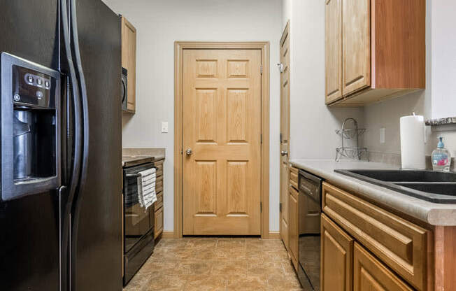 a kitchen with a refrigerator and a sink and a door