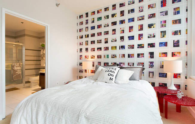 a bedroom with a bed and a wall of photos
