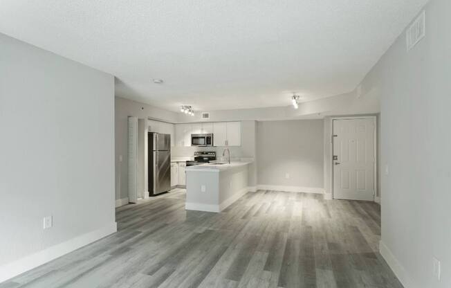A spacious kitchen with a refrigerator, sink, and cabinets.
