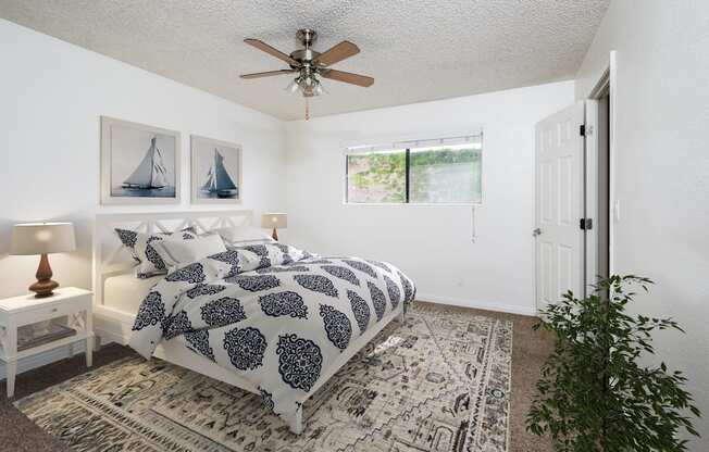 a bedroom with a bed and a ceiling fan