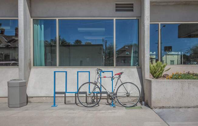 A bicycle is parked next to a blue bike rack.
