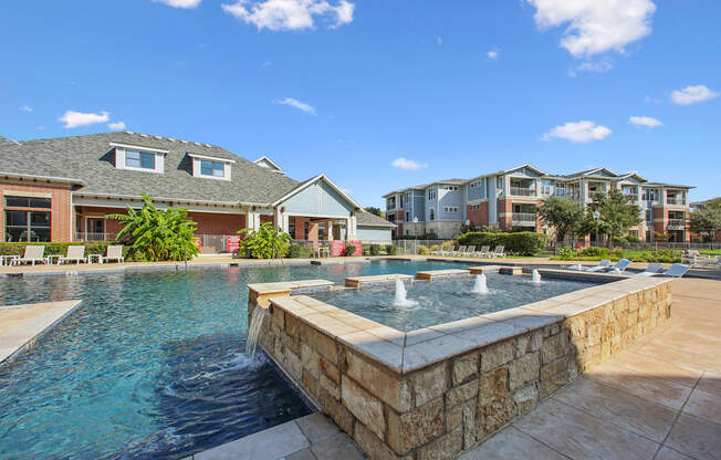 A swimming pool with a waterfall in the middle of it.