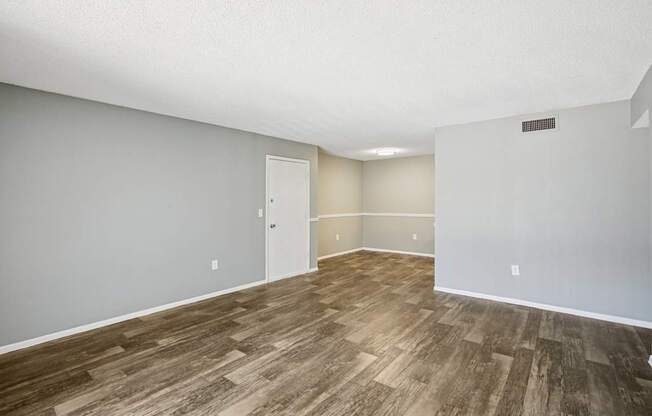 A room with wooden flooring and a white door.