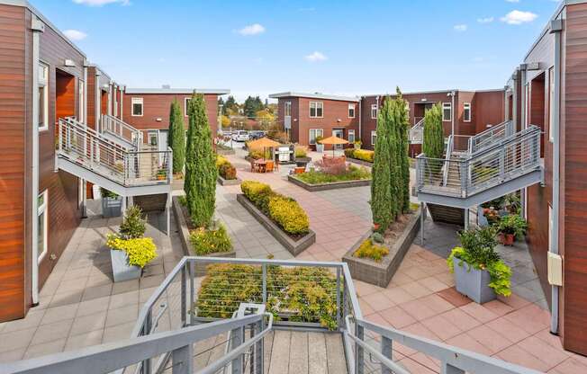 A view of a courtyard with a metal railing in the foreground.