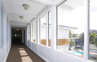 Hallway white walls and windows overlooking pool area