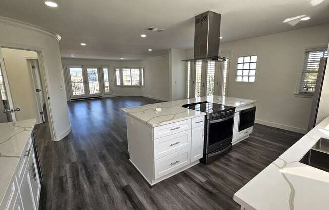 a kitchen with a center island and a stove and a living room
