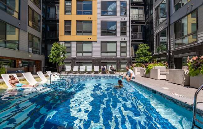 A swimming pool in a courtyard surrounded by buildings.