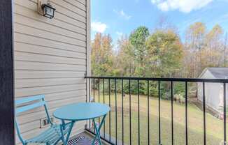 A balcony with a blue chair and table.