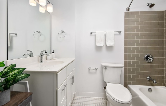 A white toilet sits in a bathroom next to a white sink.