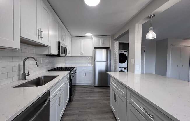 a kitchen with white cabinets and a large counter top