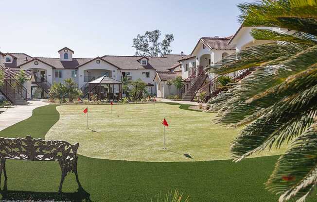 A golf course is in the front of a large house.