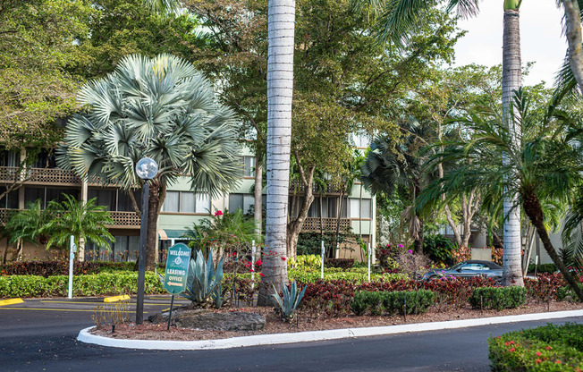 a street with palm trees in front of an apartment building at Fairways of Inverrary, Florida