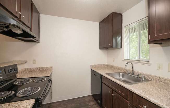 A kitchen with a countertop and a stove top oven at Pepperwood Apartments, California, 95661