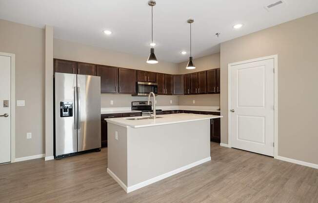 A modern kitchen with a stainless steel refrigerator and wooden cabinets.