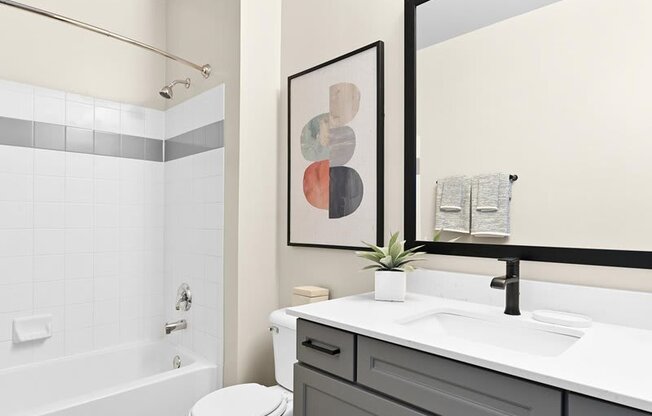bathroom with modern gray cabinets and a tub in a Farmington Lakes home