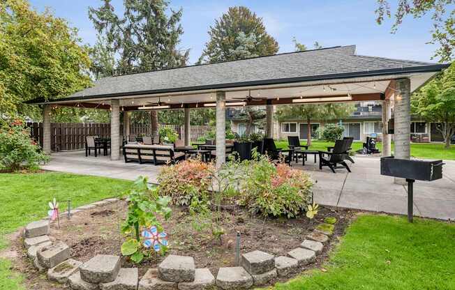 A gazebo is surrounded by a circular garden with a mailbox on the right.