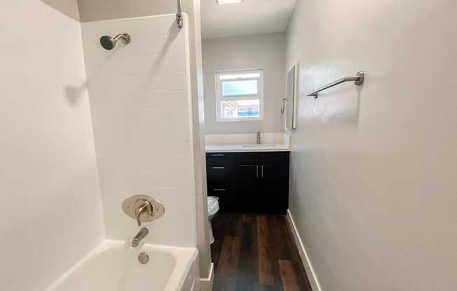 a bathroom with a tub and a shower and a sink