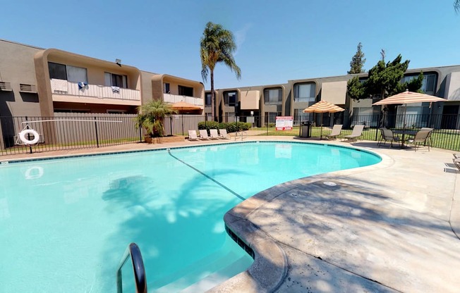 a large swimming pool with apartments in the background