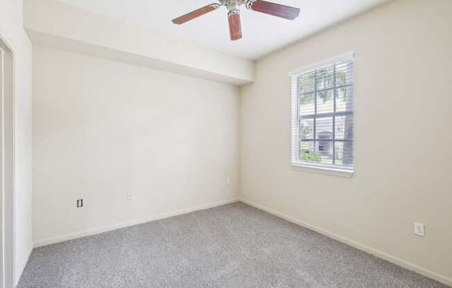A room with a ceiling fan and a window.
