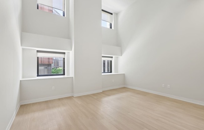 A large empty room with wooden floors and white walls.