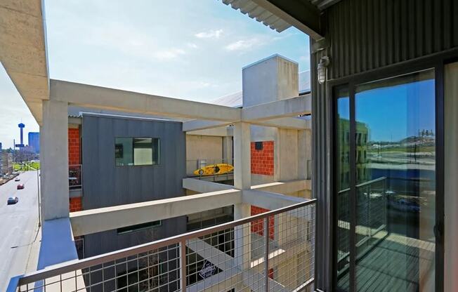 a view of a building from a balcony with a glass door