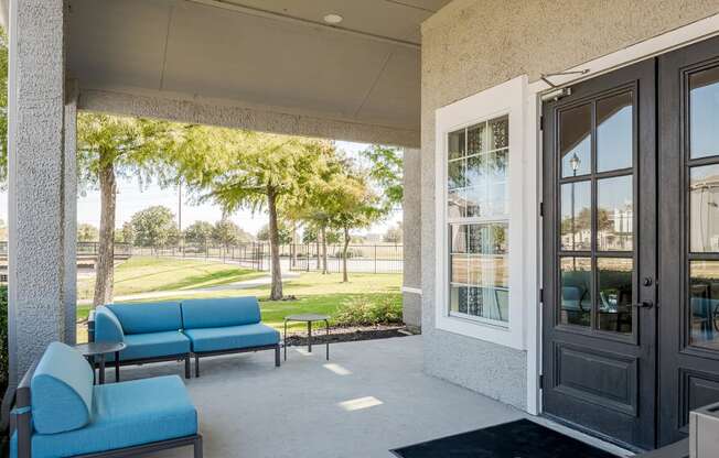 a patio with blue couches and chairs and a door