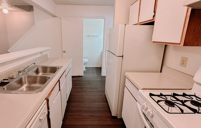 a kitchen with a stove and a sink and a refrigerator