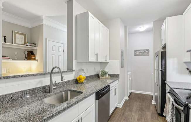 A kitchen with granite countertops and white cabinets.