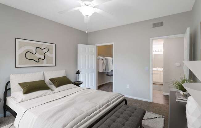 A bedroom with a large bed and a painting on the wall.