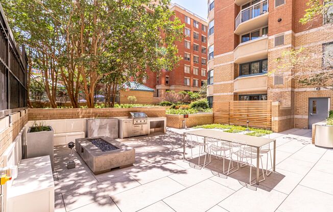 a patio with a table and chairs and a fire pit