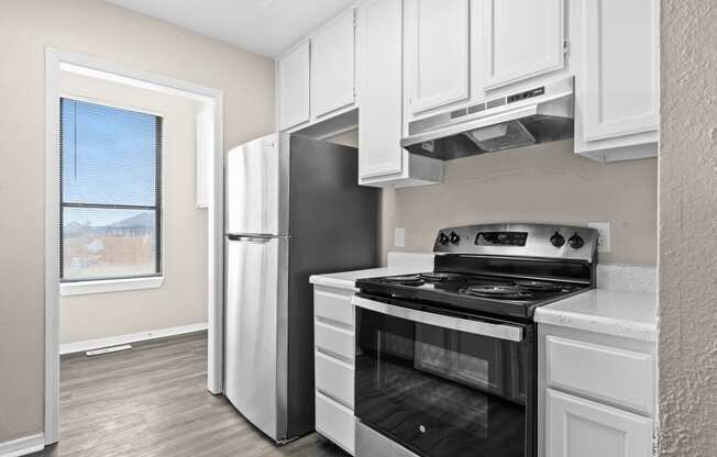 an empty kitchen with a stove and a refrigerator at Diamond Ridge Townhomes, Oklahoma City, OK 73114