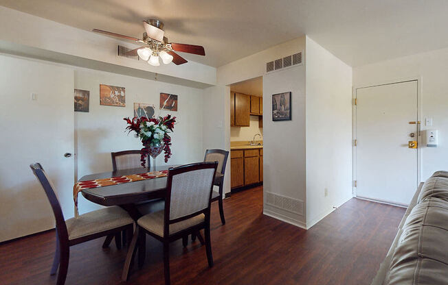 a living room and dining room with a table and a ceiling fan