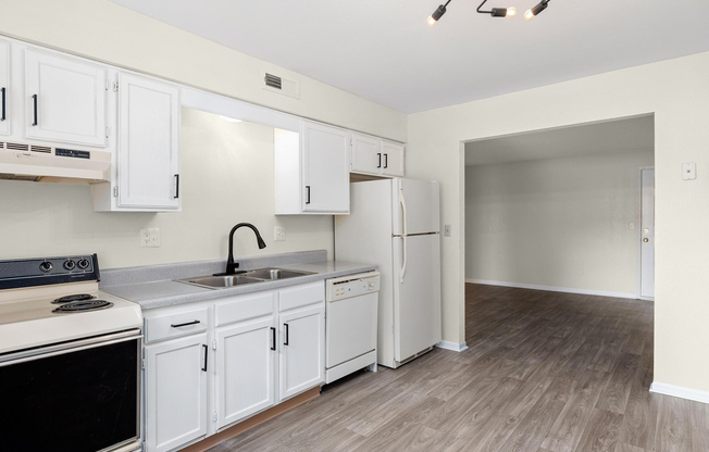 Gold kitchen interior with appliances at The Arbor Apartments in Blue Springs, Missouri