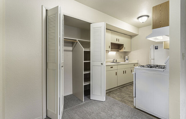 a kitchen with white appliances and a closet