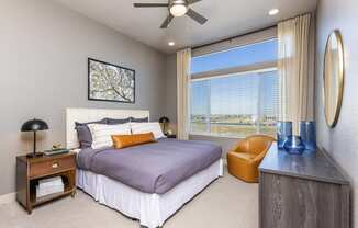 apartment bedroom has a large window and lighted ceiling fan at Zeta Luxury Apartments in Sacramento, CA