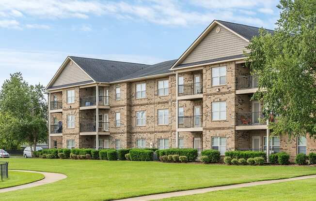 A large apartment building with a grassy area in front.